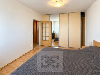 Minimalistická ložnice s dřevěnou skřín