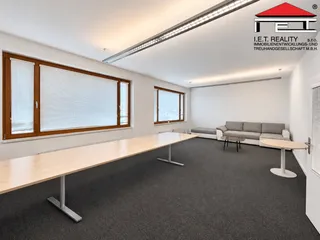 Minimalistická kancelář s dřevěným stolem a okny