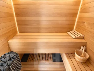 Moderní dřevěná sauna s kamny a vědrem
