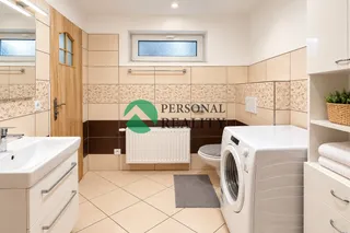 Moderní béžová koupelna s prádelnou