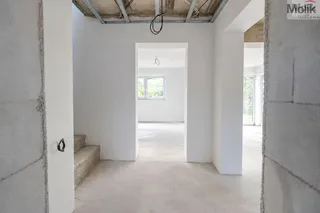 Nedokončený světlý interiér s výhledem do zeleně