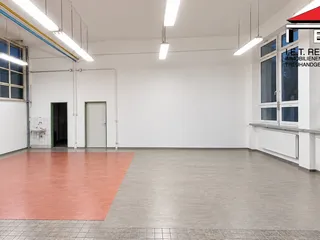 Světlá prázdná průmyslová dílna s červenou podlahou